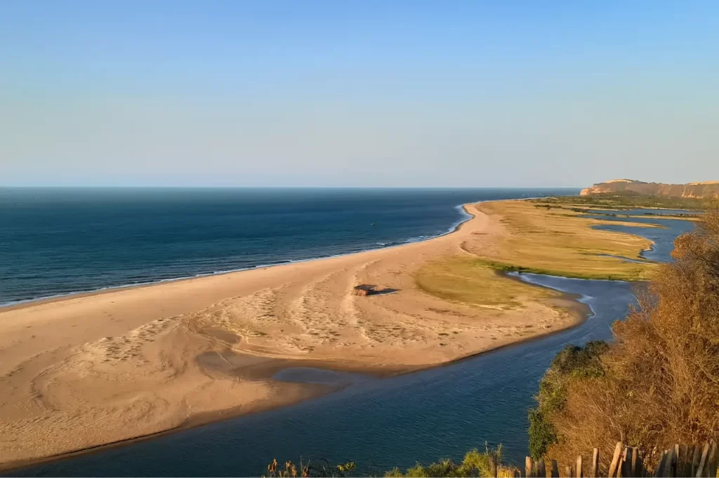Paisagem costeira tranquila ideal para turismo de bem-estar no Brasil, com praia deserta e natureza preservada.